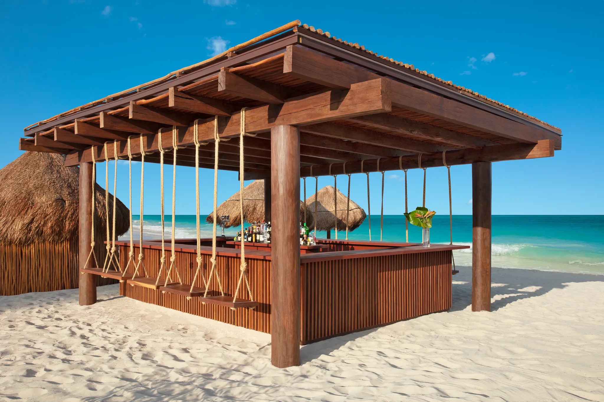 Bar de praia com balanços sobre a areia branca na Riviera Maya